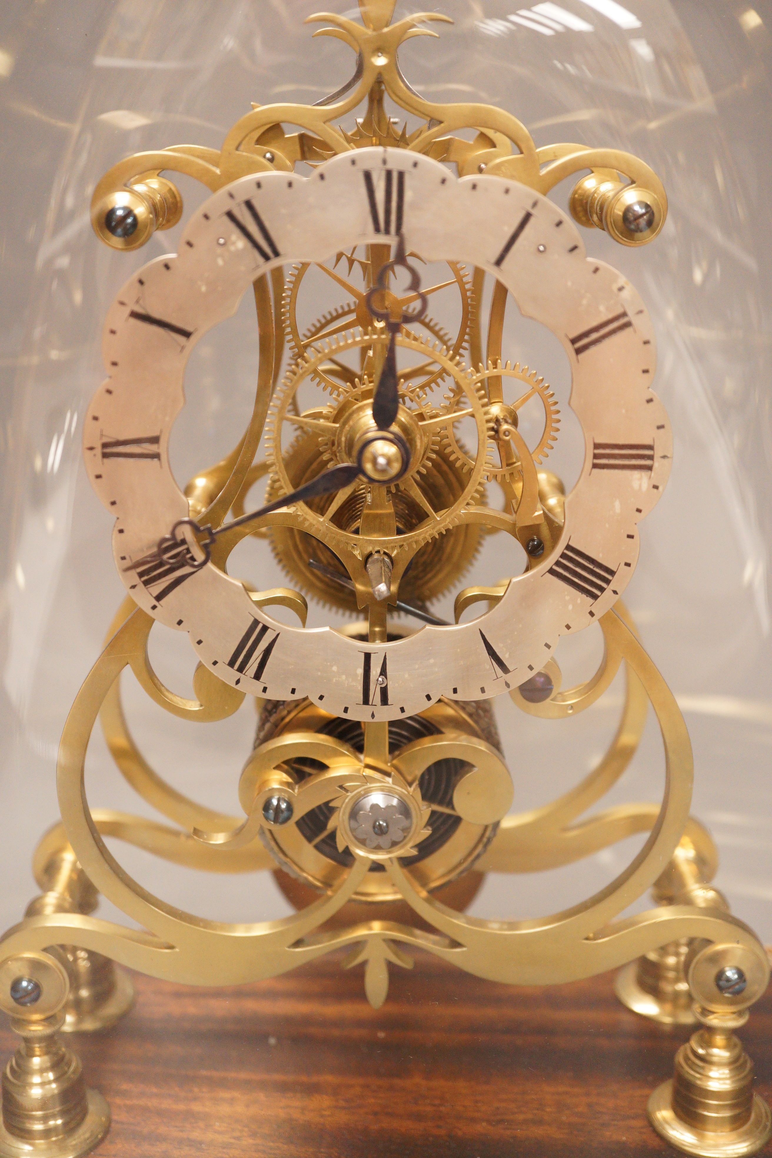 A 19th-century brass single fusee skeleton timepiece under dome, with wall bracket